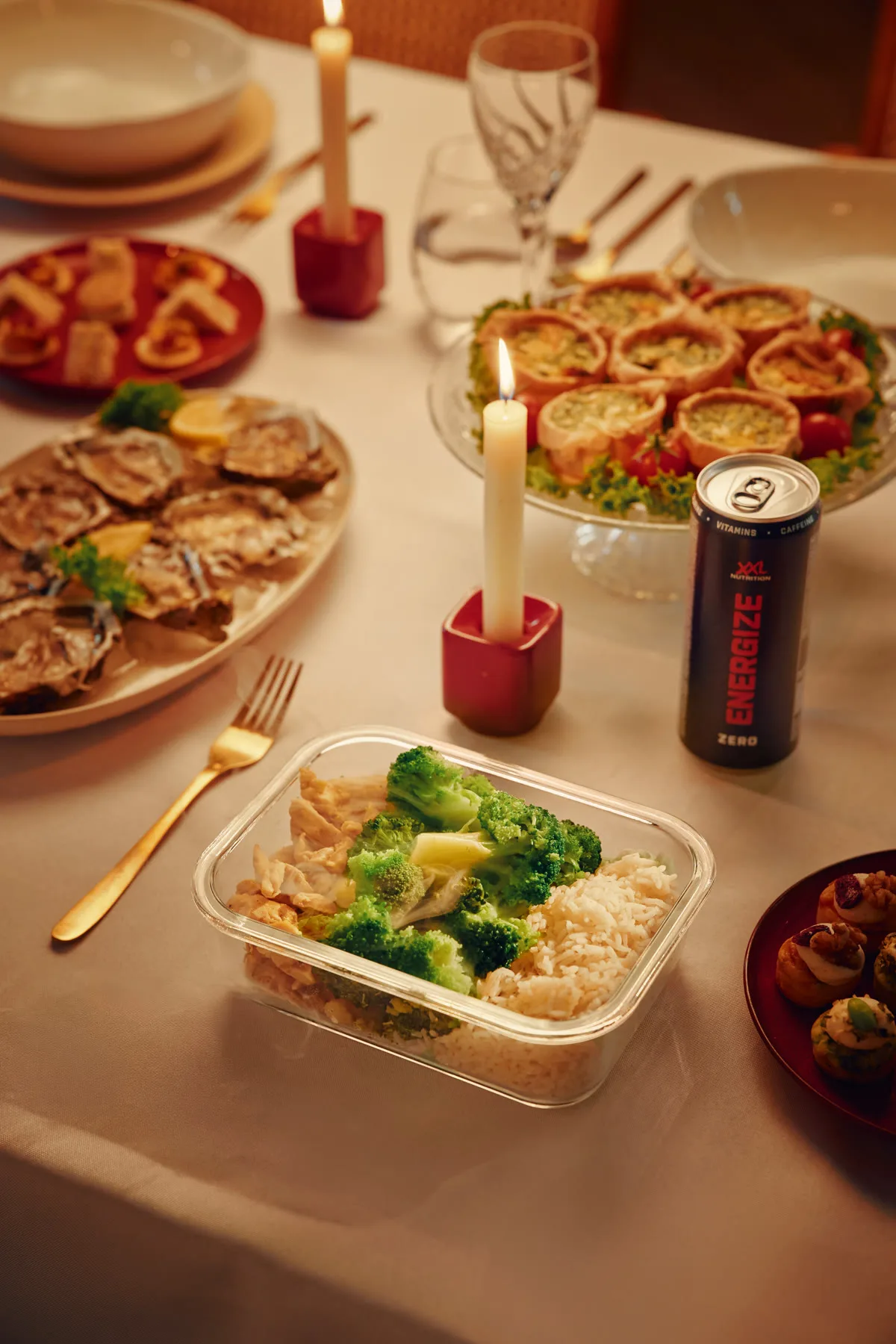 Kersttafel met een meal-prep bakje en een blikje Energize tussen het kerstdiner
