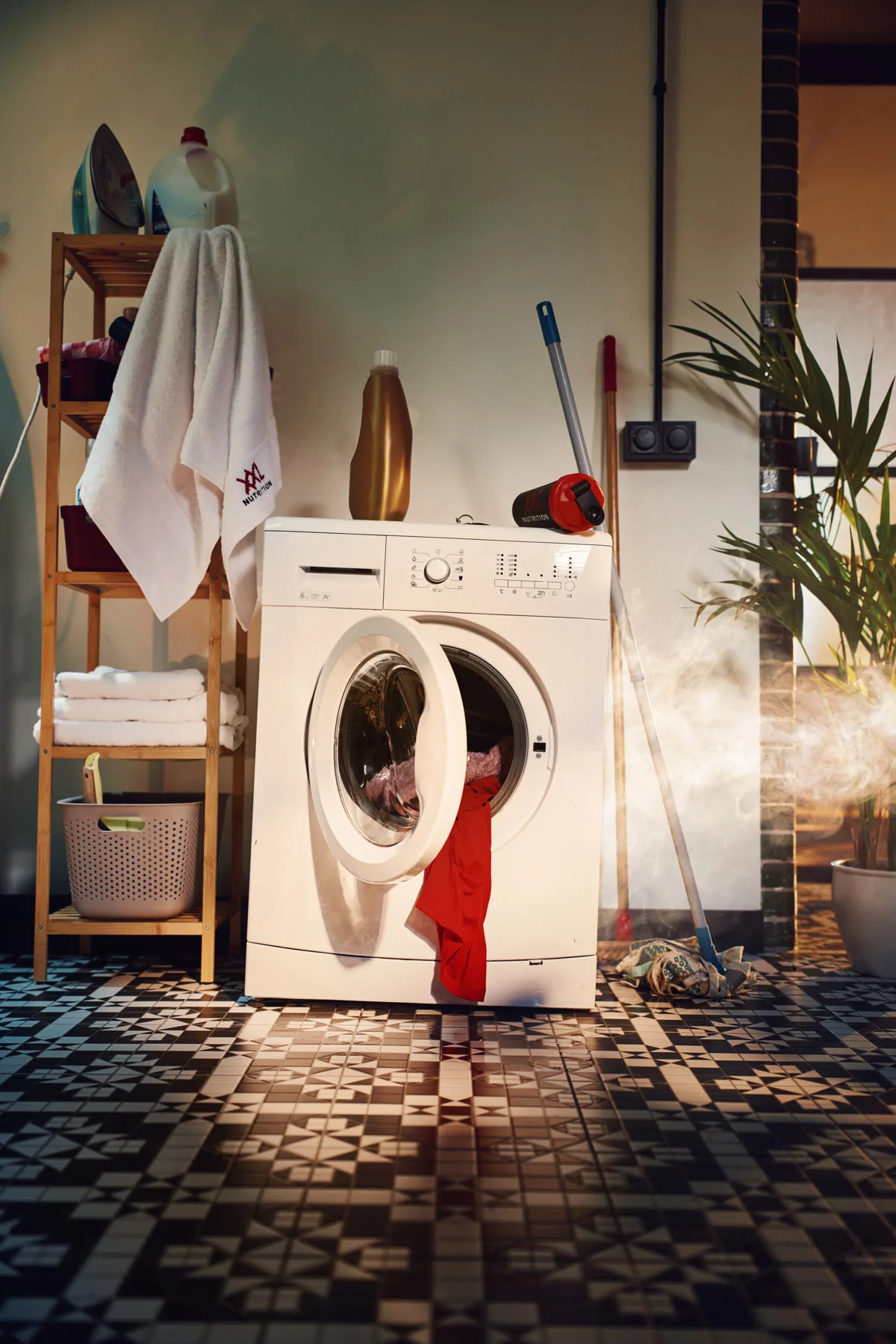 Wasmachine met rode sportkleding die eruit hangt, staand formaat